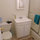 Remodeled bathroom with toilet, sink, shower and good lights over mirror.
