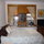 View of bed with windows looking into courtyard, 32" TV with cable, and french doors to private porch