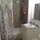 Bathroom has stone floors/walls, bathtub and massaging showerhead.