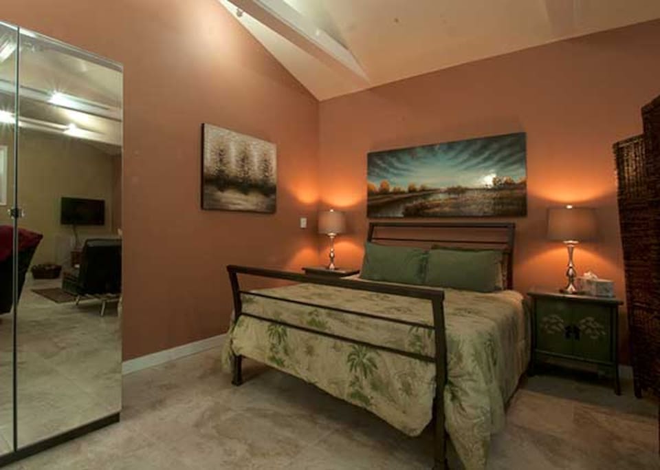 Queen size bed tucked away with privacy screen