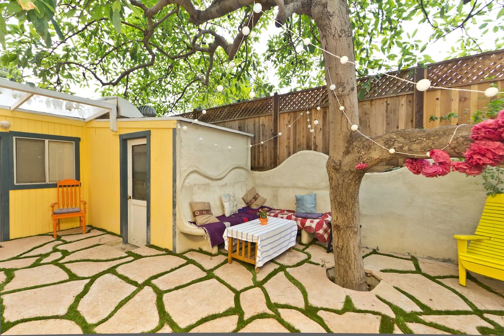 Relax on the beautiful corner bench in the shade of the avocado tree